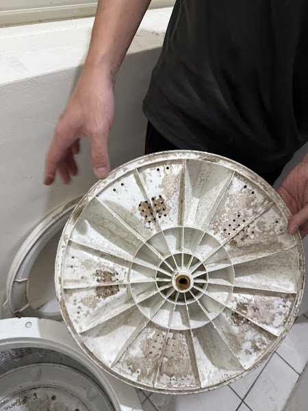 師傅展示洗衣機髒污零件